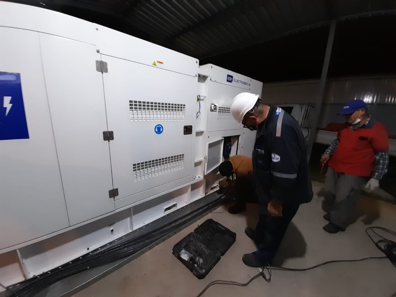 Técnico realizando mantenimiento de generador eléctrico