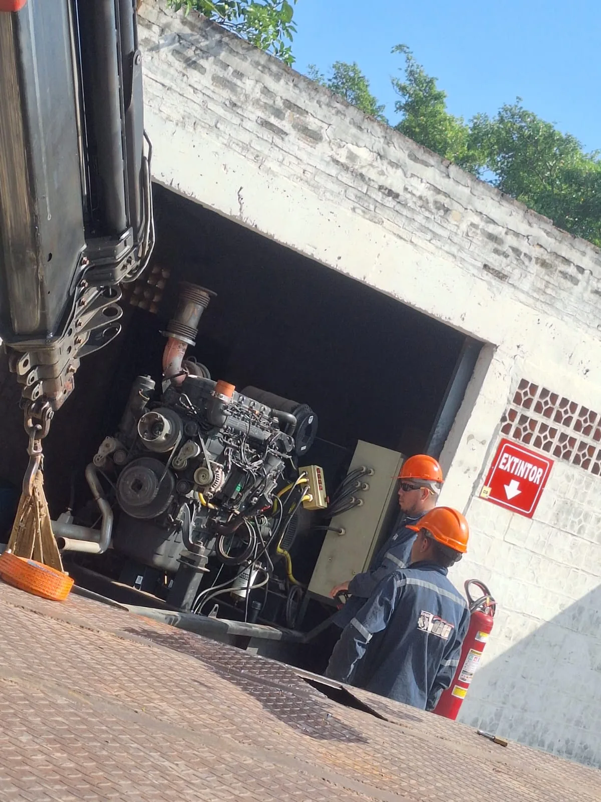 Generador RESA 450 KVA siendo preparado para retiro con grúa en recinto con señalización de extintor