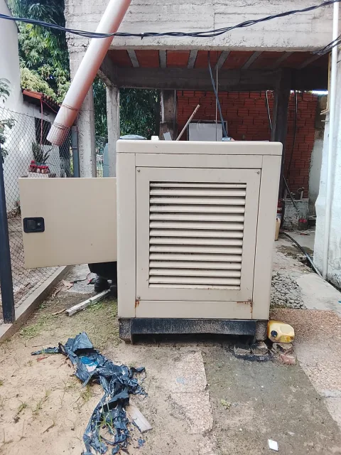 Vista frontal del generador eléctrico Gotze de 60 KVA con puerta lateral abierta en área externa del sanatorio