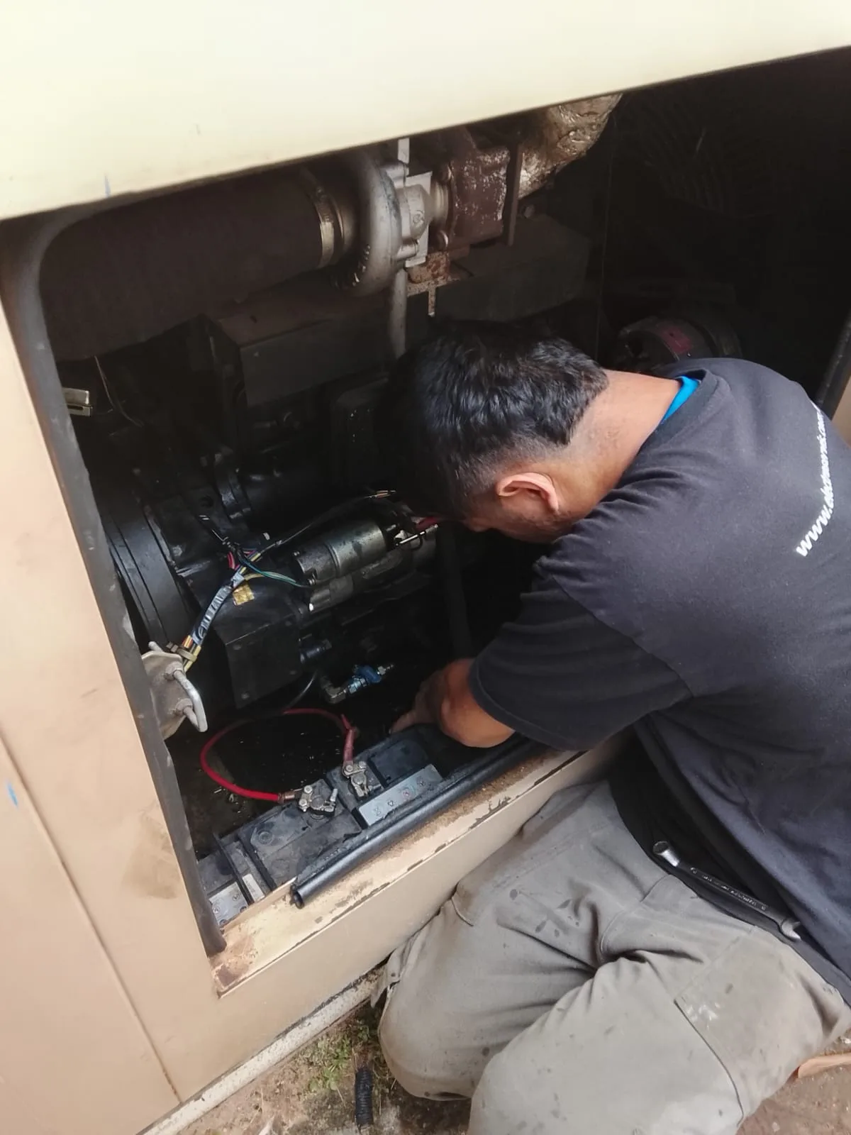 Técnico de Electroservis realizando inspección interna y ajustes en componentes eléctricos del generador Gotze de 60 KVA