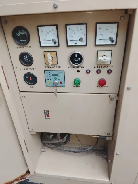 Panel de control del generador con indicadores de voltaje, frecuencia, amperaje y horas de funcionamiento