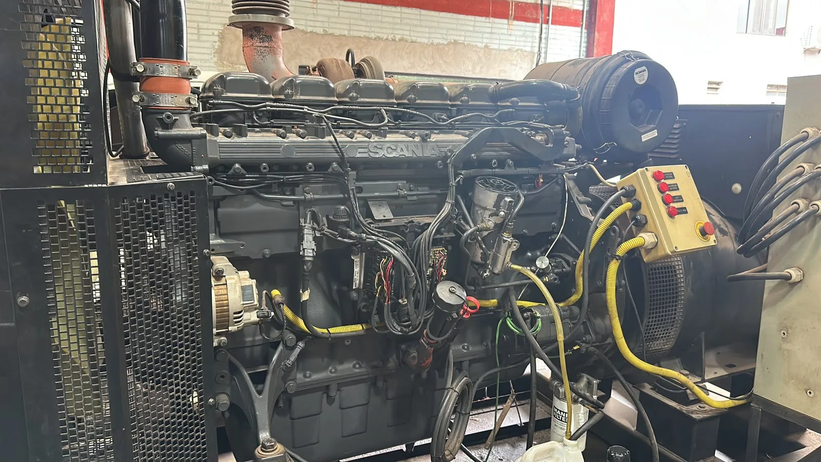 Motor diésel SCANIA de 6 cilindros instalado en generador eléctrico de 450 KVA durante proceso de reparación en taller.