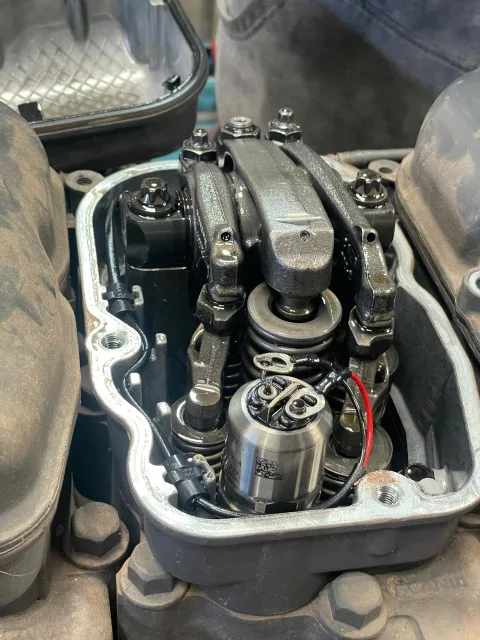 Detalle de válvulas y solenoide de inyector del cilindro 4 de motor SCANIA durante reparación, mostrando componentes mecánicos en taller.