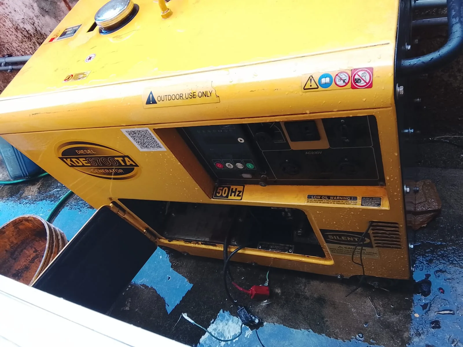 Generador Kipor 8 KVA con tapa lateral abierta y signos de humedad en su entorno durante inspección técnica en Asunción.