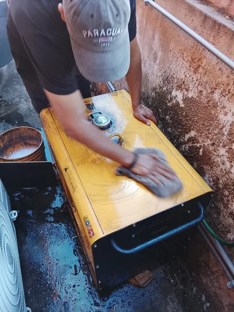 Técnico limpiando minuciosamente la superficie del generador Kipor para eliminar suciedad y asegurar óptimo funcionamiento.