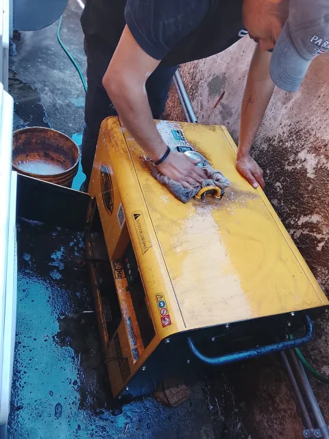 Técnico realizando limpieza con paño húmedo al generador Kipor para eliminar residuos que podrían afectar el desempeño.