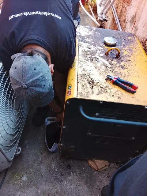 Especialista inspeccionando y ajustando conexiones eléctricas internas del generador Kipor para asegurar contacto correcto y seguro.