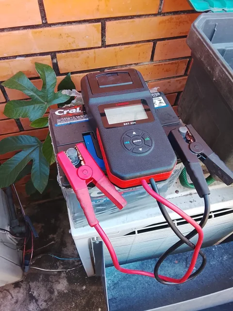 Equipo de diagnóstico conectado a batería antigua del generador Kipor para verificar estado y capacidad de carga.